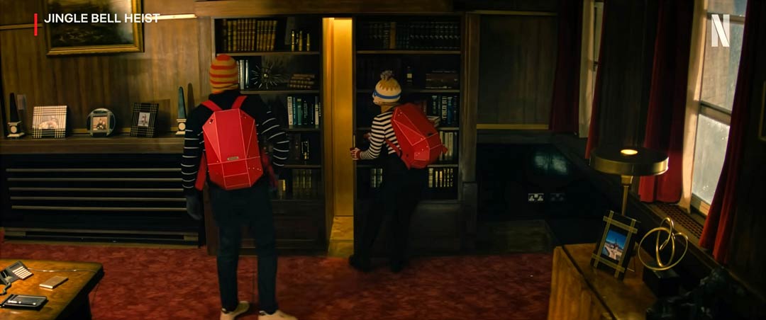 Red SOLID GRAY backpack worn by Olivia Holt and Connor Swindells in Netflix's Jingle Bell Heist (2025)
